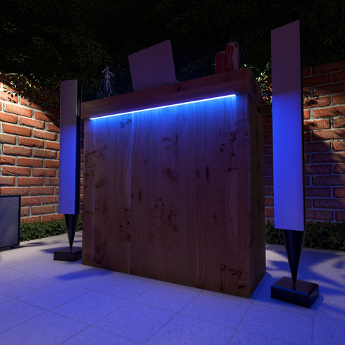 Wooden garden bar with blue LED lighting against a brick wall at night