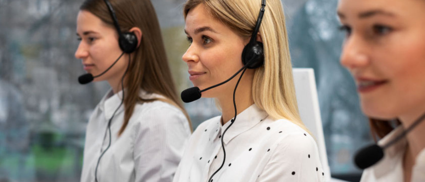 Three women wearing headsets in a call center setting