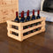 Wooden crate with six bottles of red wine on a wooden floor.