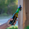 Hand using a bottle opener on a green bottle outdoors