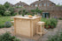 Wooden outdoor bar set up in a garden with a stool and decorative items.