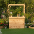 Wooden garden bar with plants and bottles in a garden setting