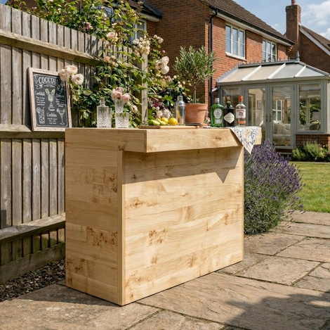 Wooden bar setup in a garden with plants and a house in the background