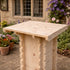 Wooden outdoor table with a rustic design in a garden setting.