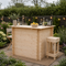 Wooden outdoor bar set with drinks and snacks in a garden setting